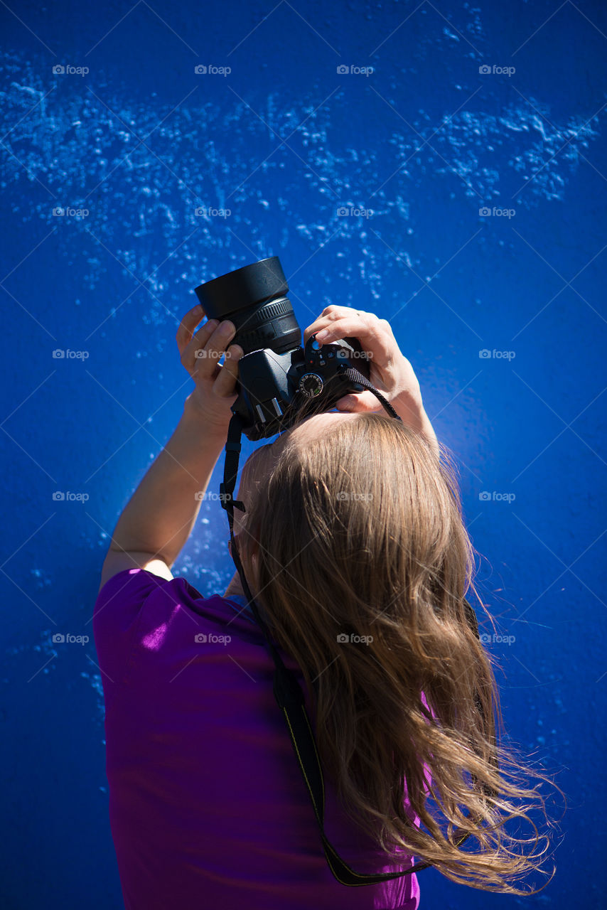 Rear view of woman with photo camera