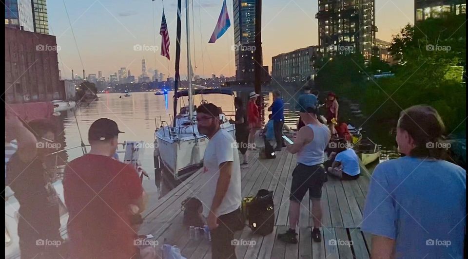 This is the crowd gathering on the docks of “Newtown Creek” to see the fireworks for the “4th of July”, “Independence Day”, a historically important date. 2023. Hypnotic Productions