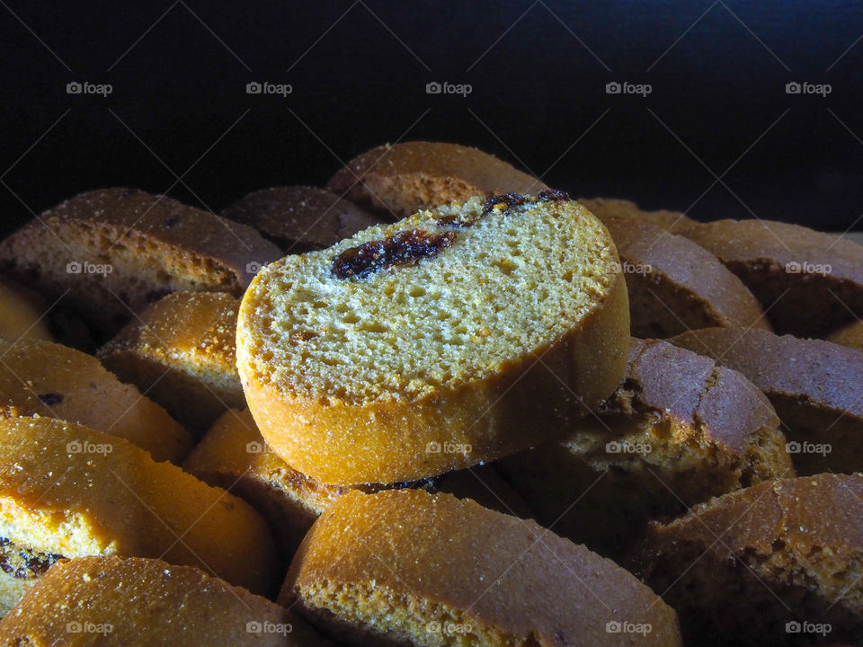 Freshly baked vanilla tasty crackers with raisins lie on a wooden table top and a dark background