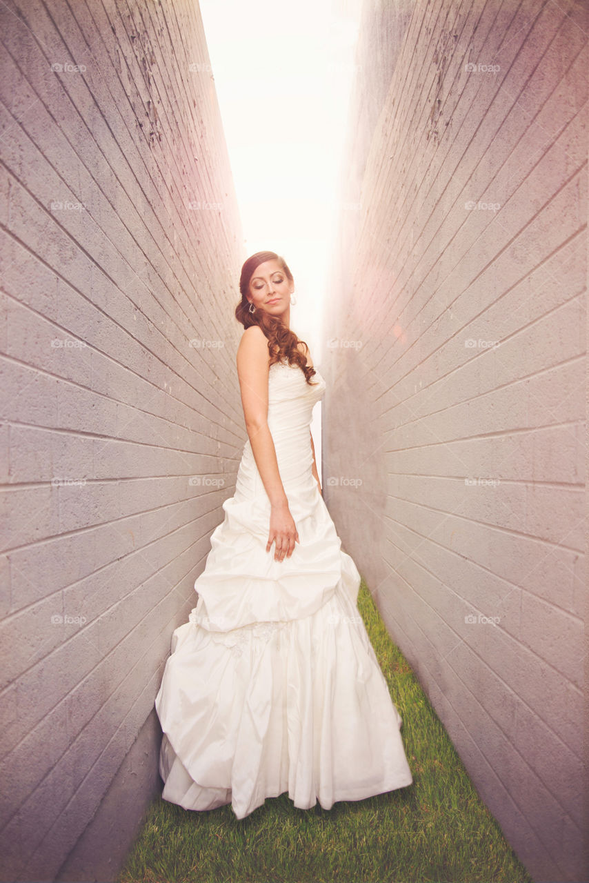 Beautiful bride standing near wall