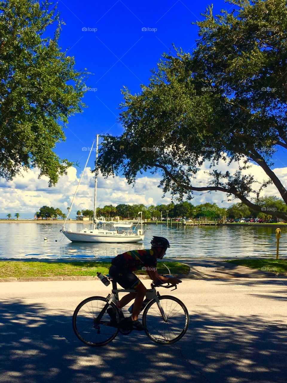 Bike rider and sailboat together 