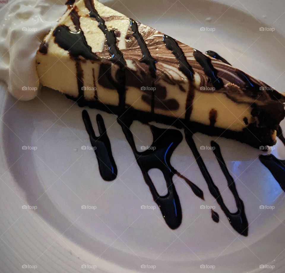 Delicious chocolate cheese cake with whipped cream drizzle in chocolate sauce