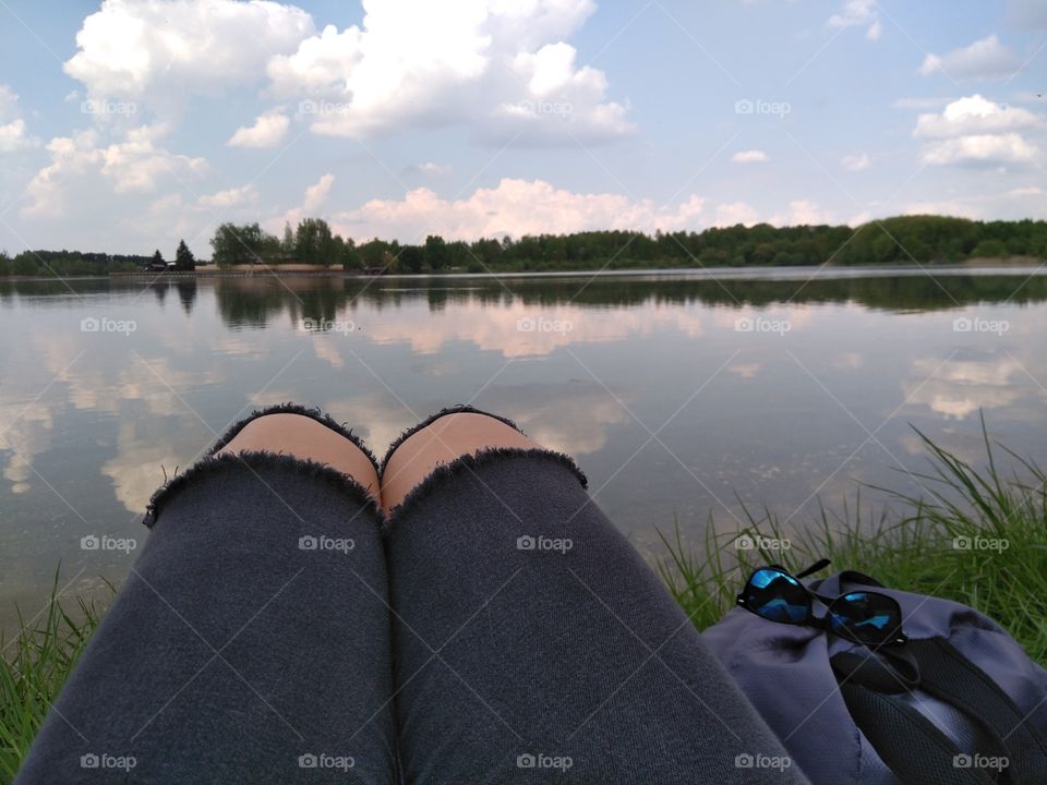 female legs resting on a lake summer landscape