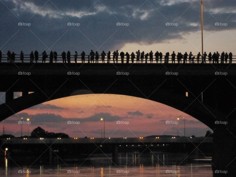 Silhouette of people on austin bat bridge