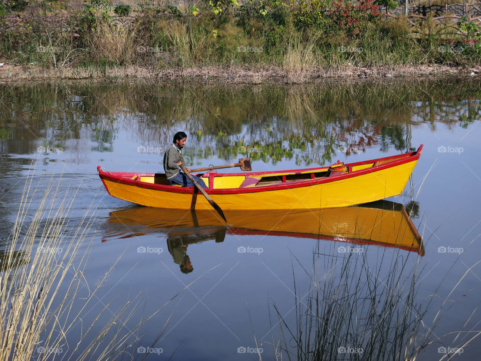 The Lone Rower. A lone rower rowing his boat at the Rawal Lake in Islamabad, Pakistan.