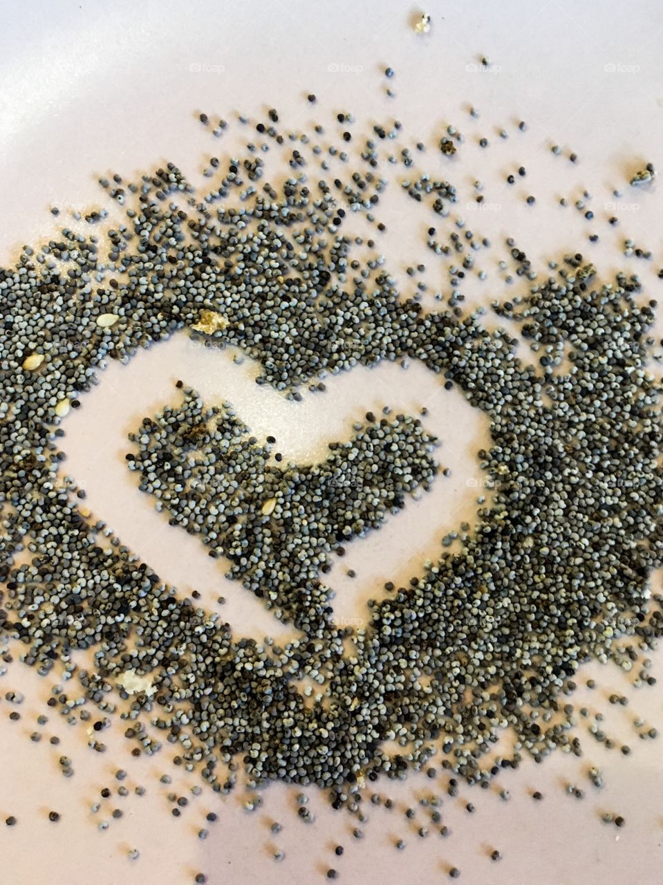 The poppy seeds on a plate. The poppy seeds background. Seeds texture. 