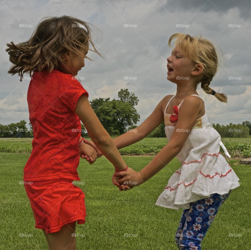Two girls playing in grassy field