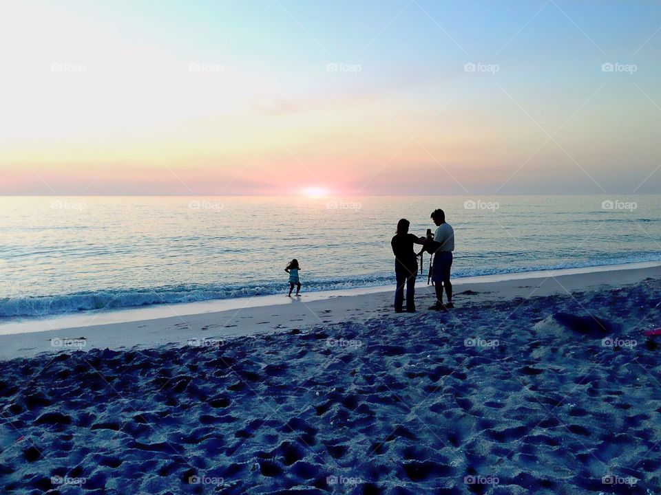 Family at sunset on the beach.