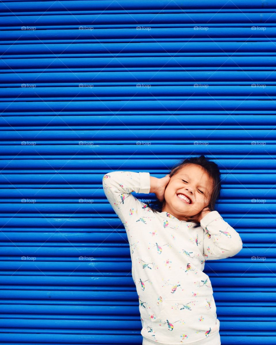 Girl standing near blue shutter