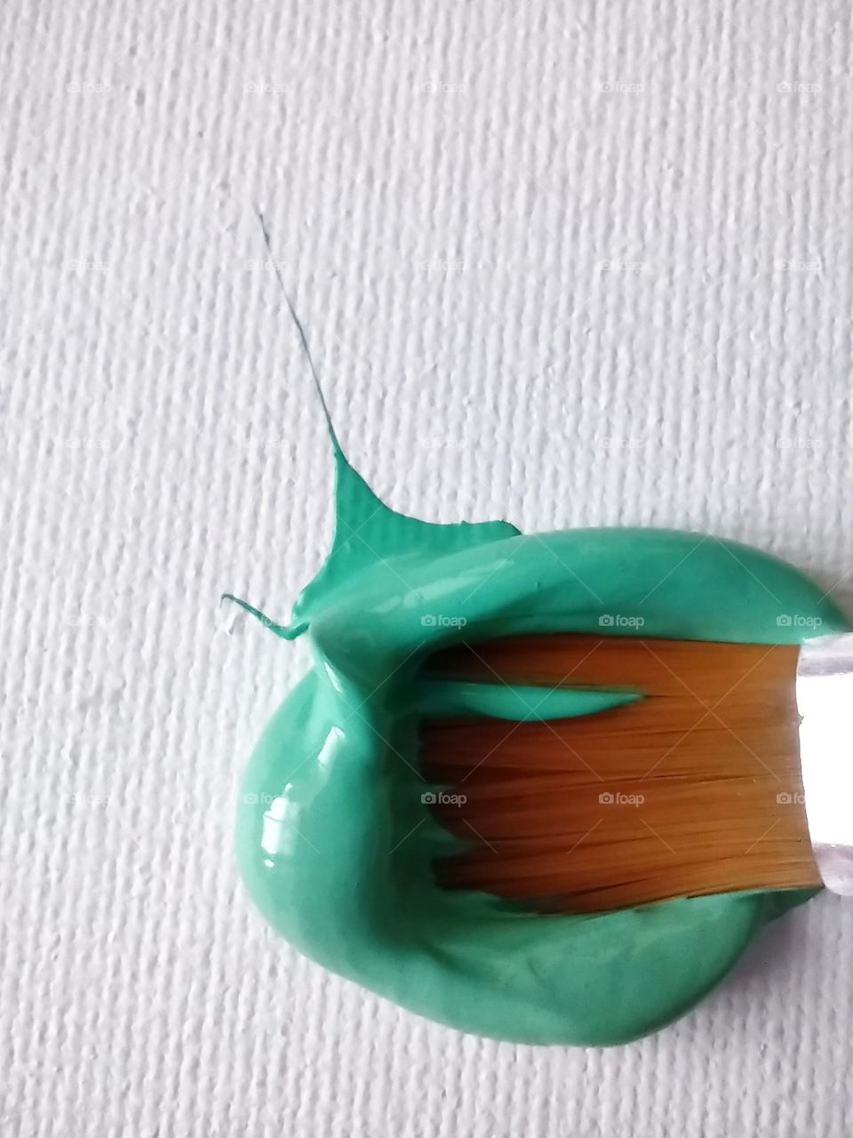Unfiltered, beautiful, lovely close-up of green paint and a paint brush