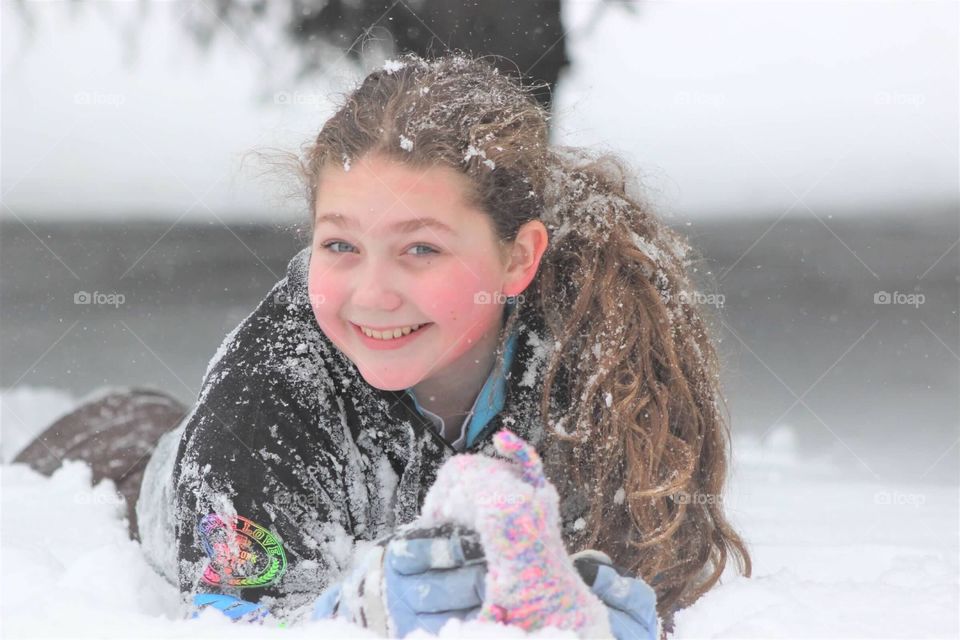 Beautiful little teenage girl enjoying the freshly fallen snow. 