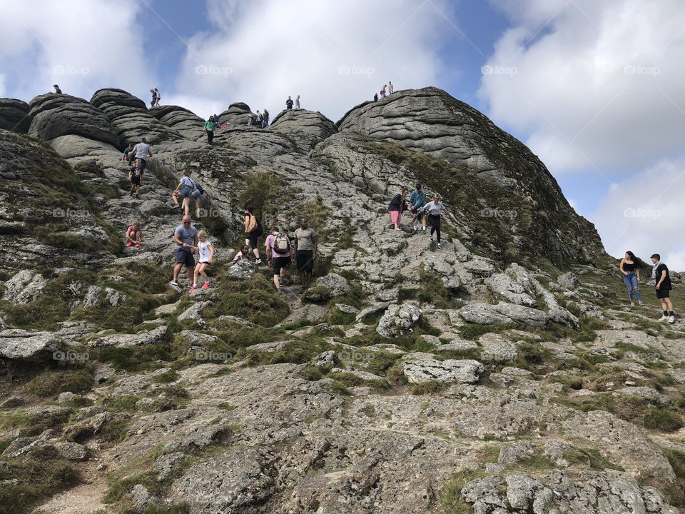 Close up of a crowded Haytor on the National Park, in Devon, UK.  On to a scorcher of a bank holiday in August 2019