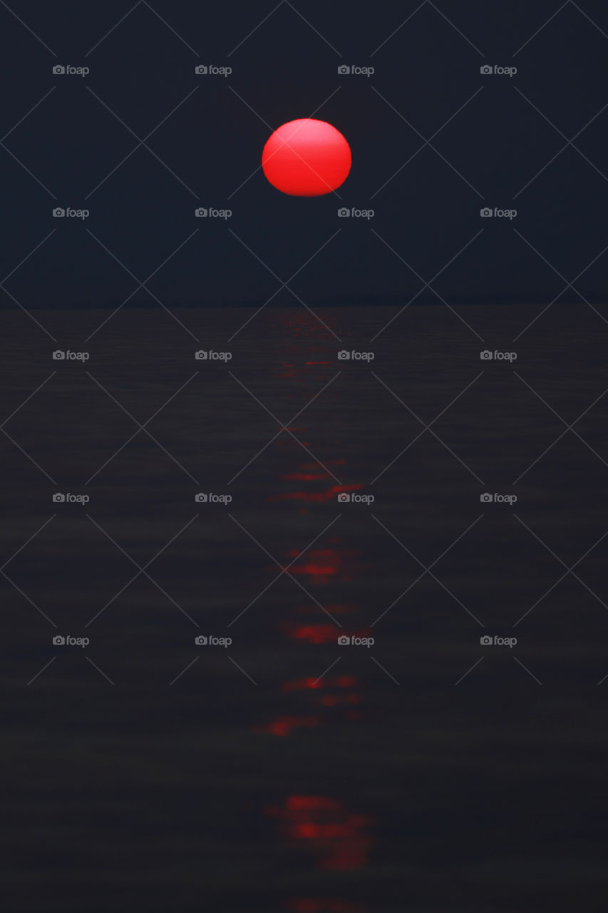 Red moon over ocean