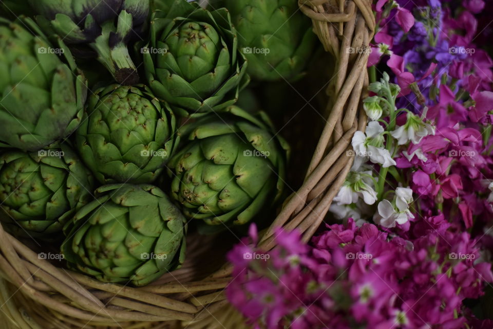 artichokes in a basket and flowers at the market