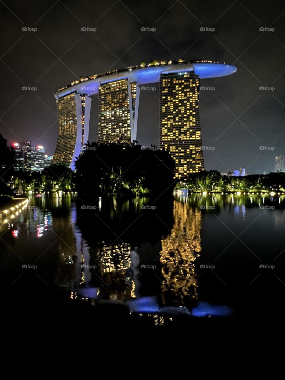 Reflection of Marina Bay Sands hotel in the water by night with illuminations.