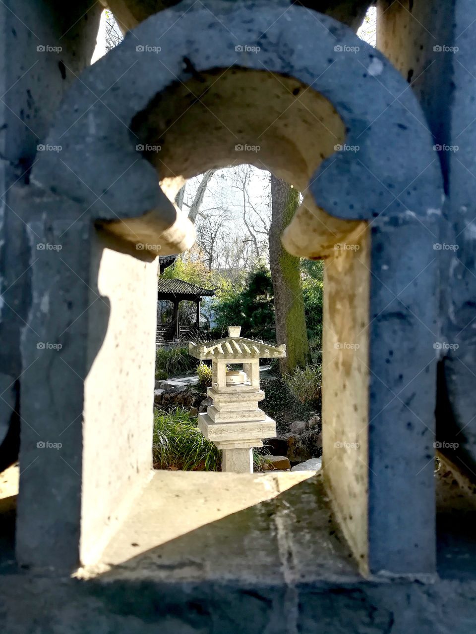 A view through a window in the wall around the Chinese Garden in Frankfurt/Main