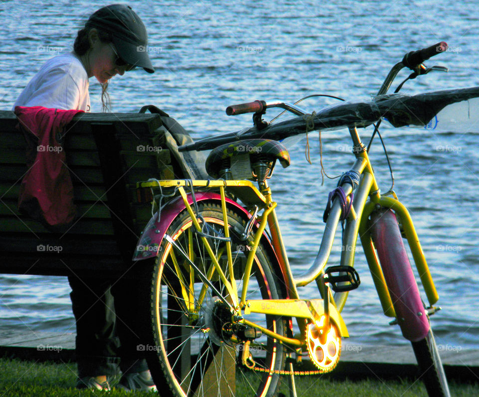 Biker at sunset. Lady with bike at park