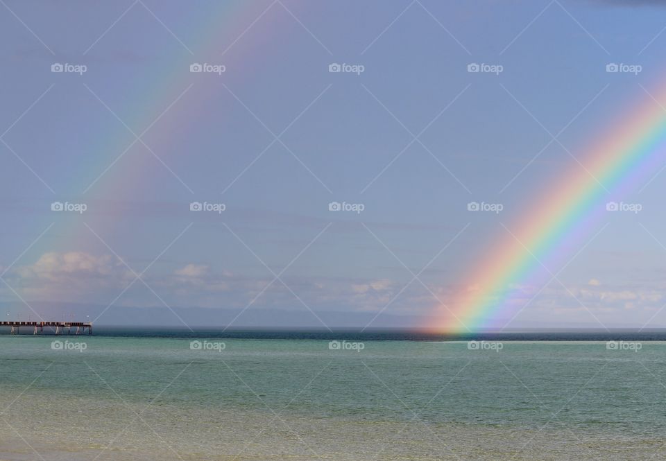 Double rainbow on ocean horizon 