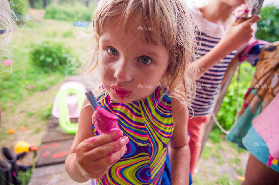 little girl is eating ice cream messily