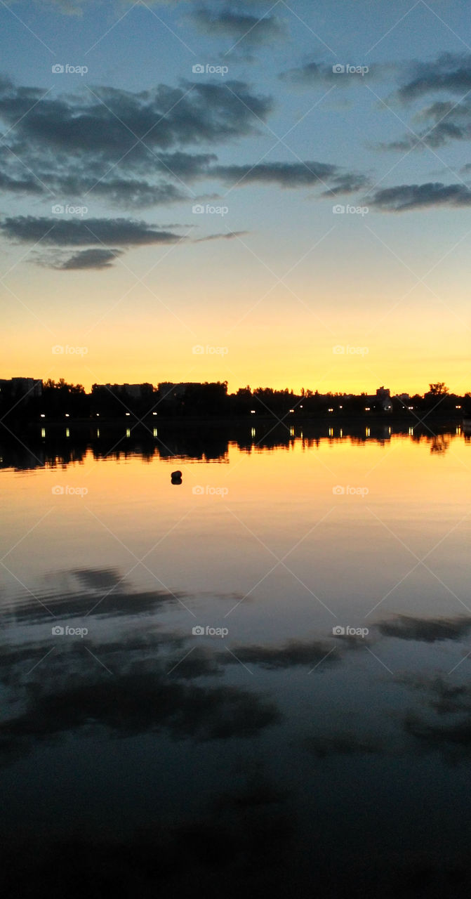 Sunset sky above the city park lake