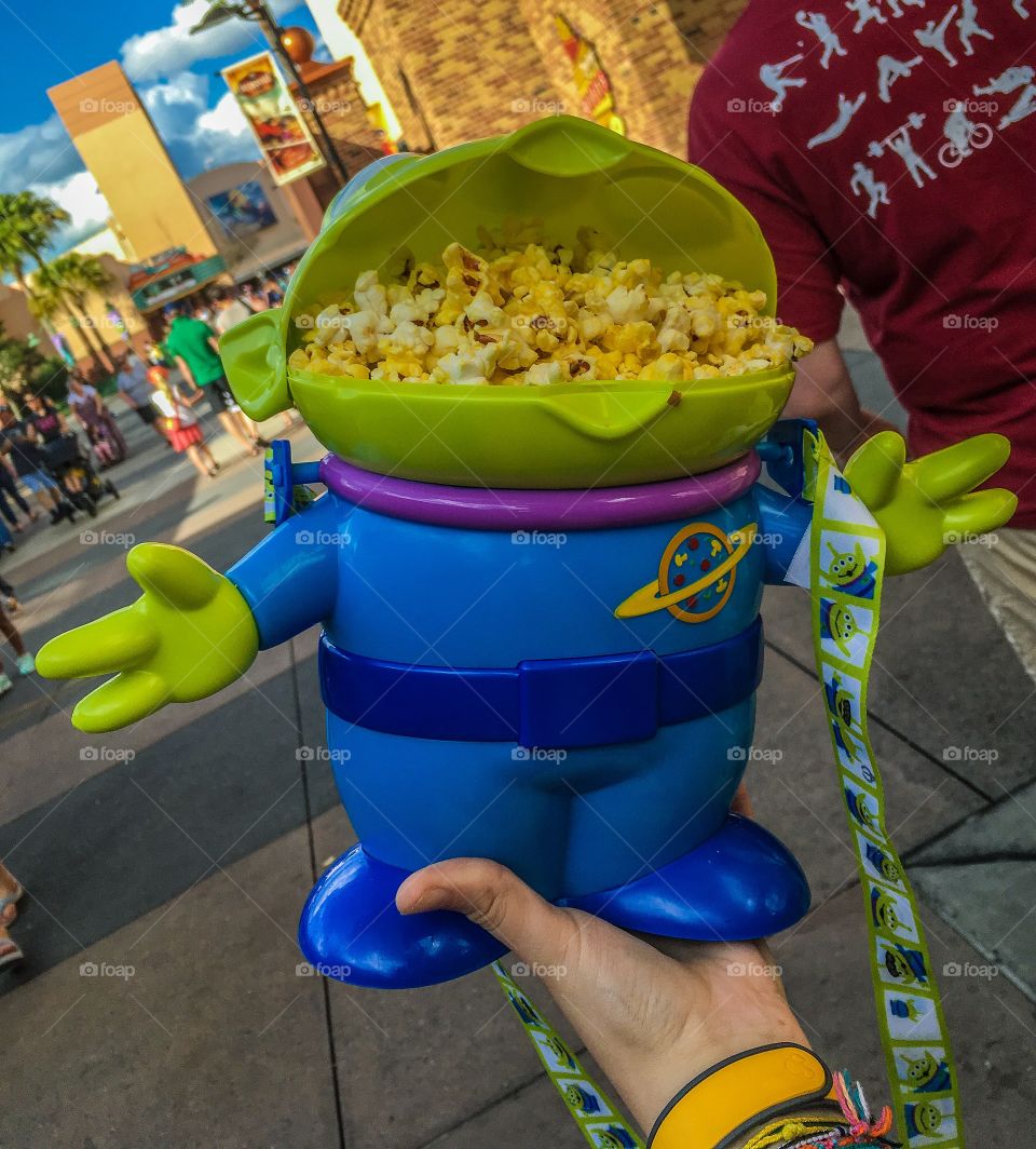 Popcorn buddy. Little green man filled with popcorn with a strap for easy carrying.  