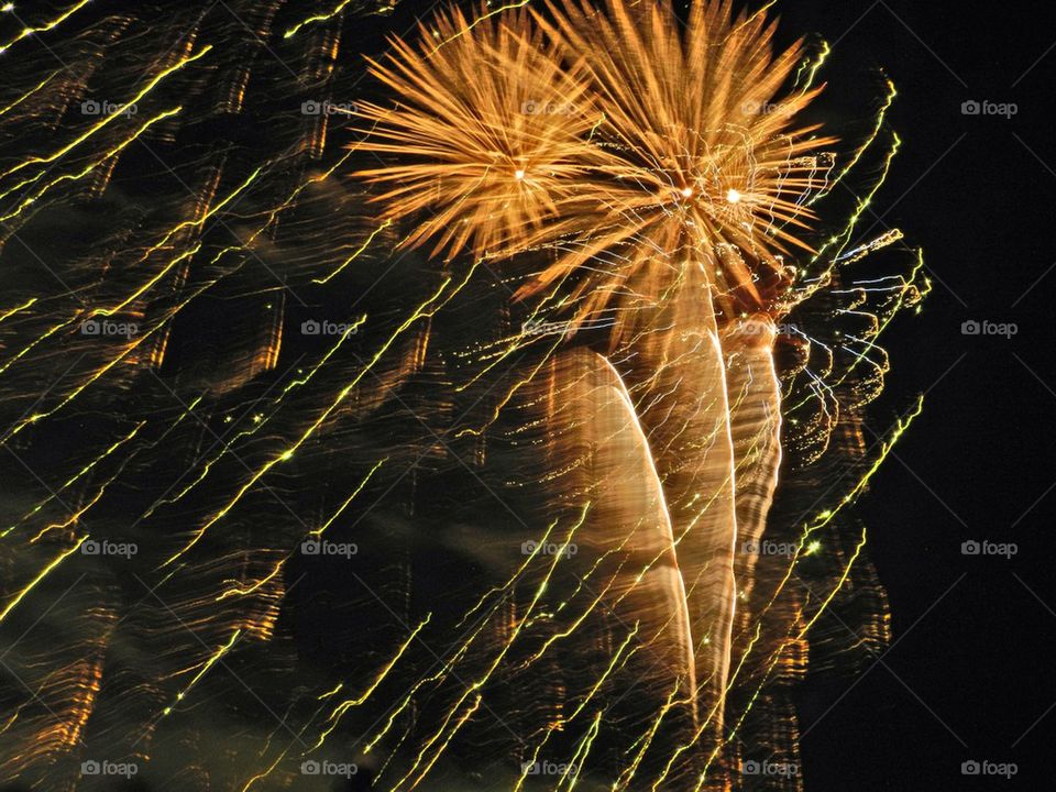 Low angle view of fireworks against sky at night