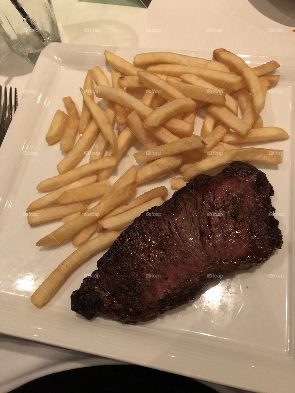 Steak and fries on a plate.