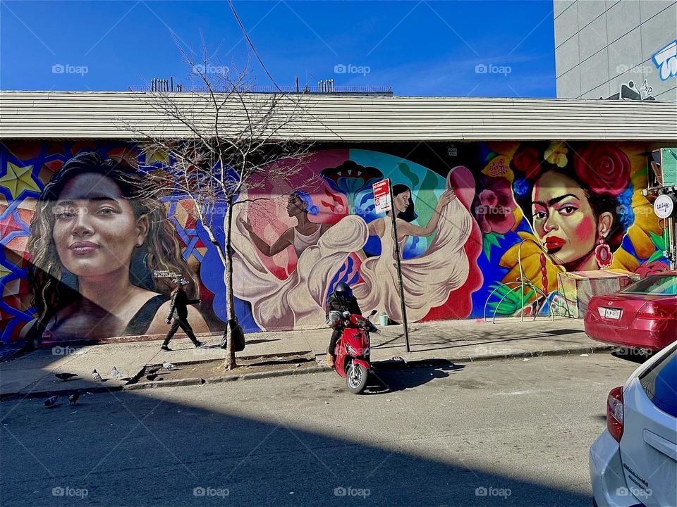 This is a beautiful one story tall art mural on „Jefferson St“ off „Broadway“ in „Bushwick“, Brooklyn showing Latin elements, a dancer in a long flowing white dress and the words „PRIDE“. 2024. Hypnotic Productions