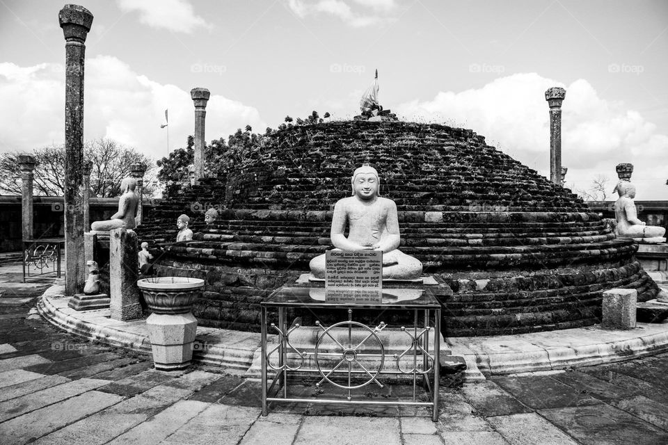 Ruins of an ancient pagoda building in the eastern part of Sri Lanka. A structure with a roof and the pagoda inside.