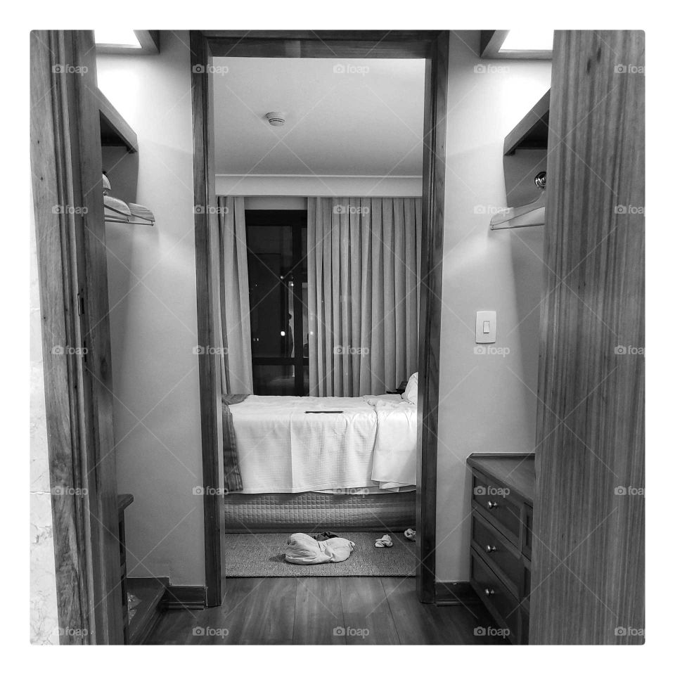 Retrato de um quarto de hotel com reflexos ocultos, algumas roupas pelo chão e pequenas mensagens subjetivas.