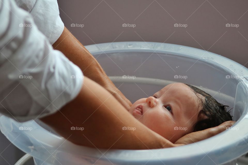 Unrecognizable father bathing his little baby son