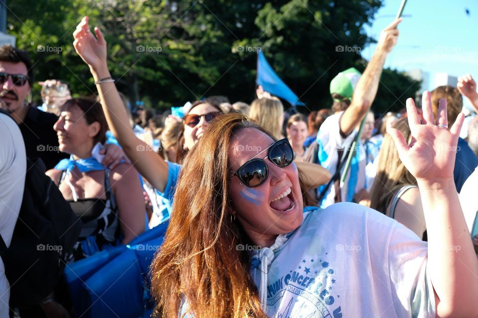 Buenos Aires - 18.12.2022: Smiling football fans in t-shirt of the national team of Argentina celebrating victory on the street