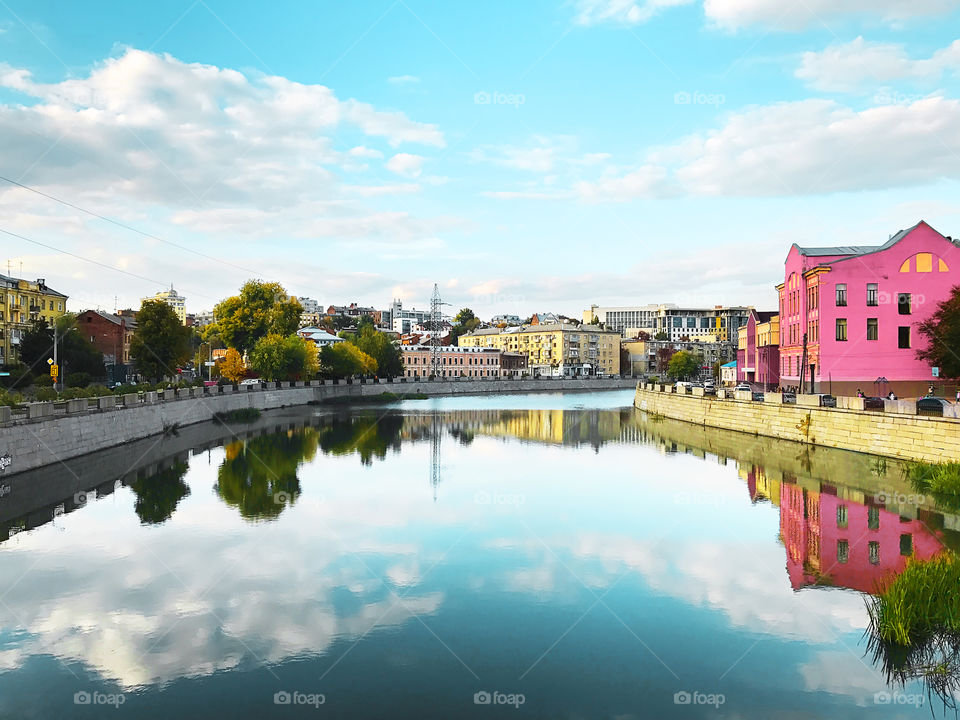 Beautiful reflection of cityscape in front of blue cloudy sky in the river 