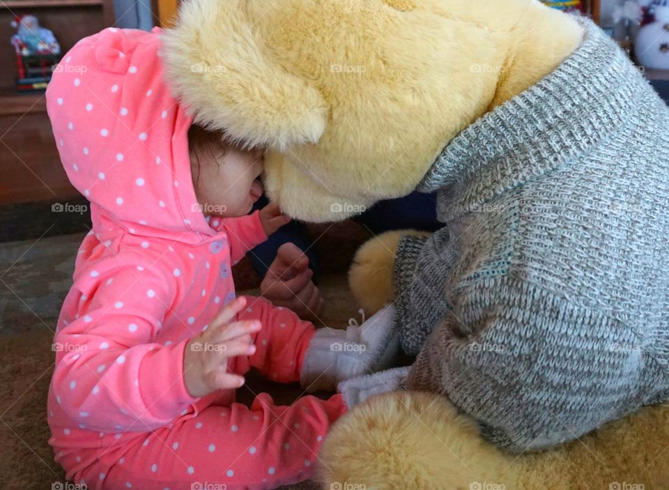 Baby playing with soft teddy bear