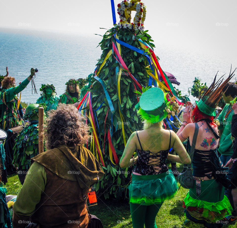 A seen from a UK festivity, people are dressed in green and dance, sing and play instruments around a leafy, twirling fellow called “the Jack” - Hastings, East Sussex 