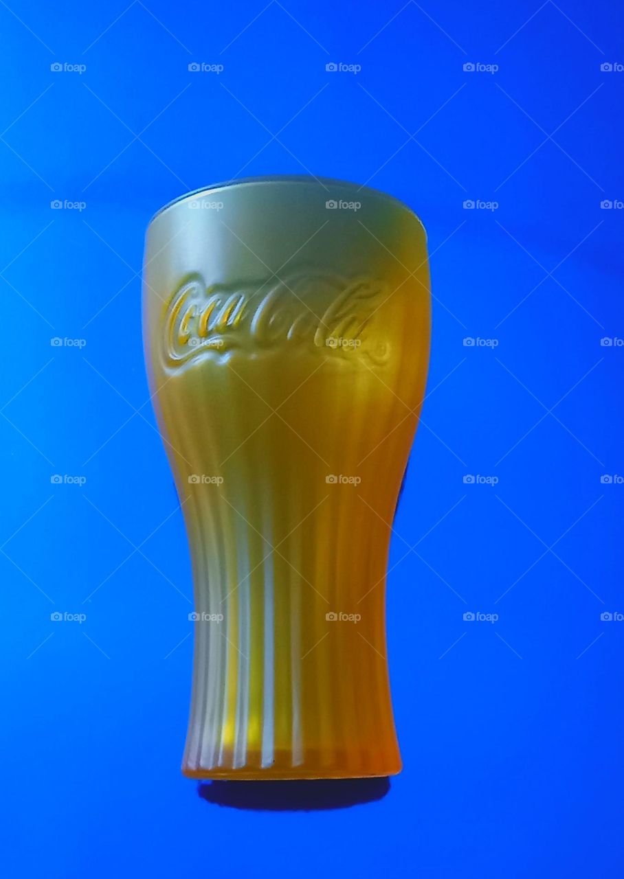 Vaso naranja sobre fondo azul