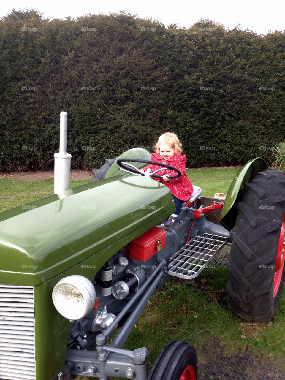 Young girl on large tractor.