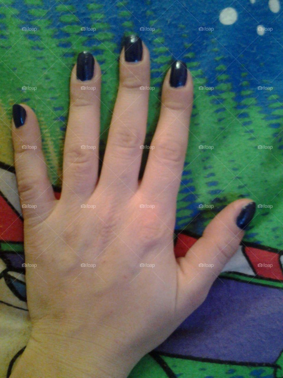 mano azul uñas pintadas
