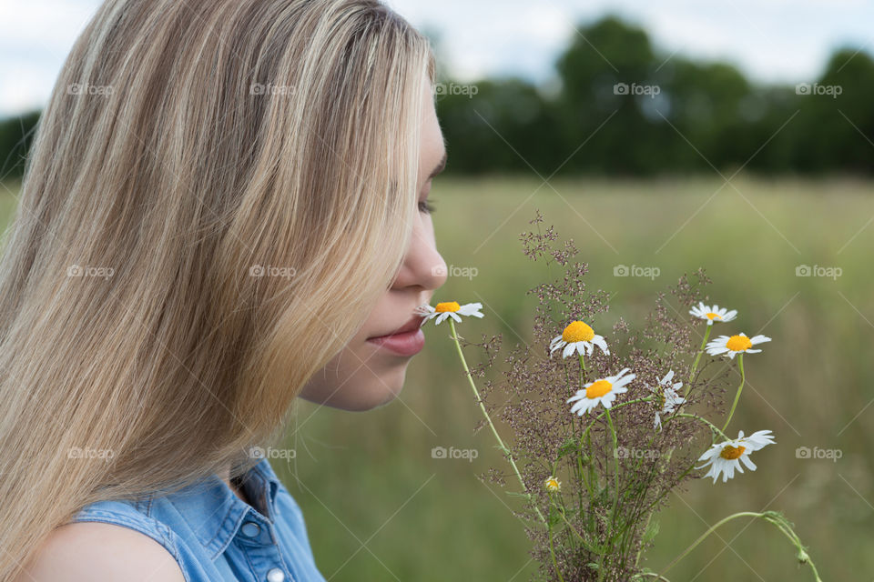 a girl with daisies in the field