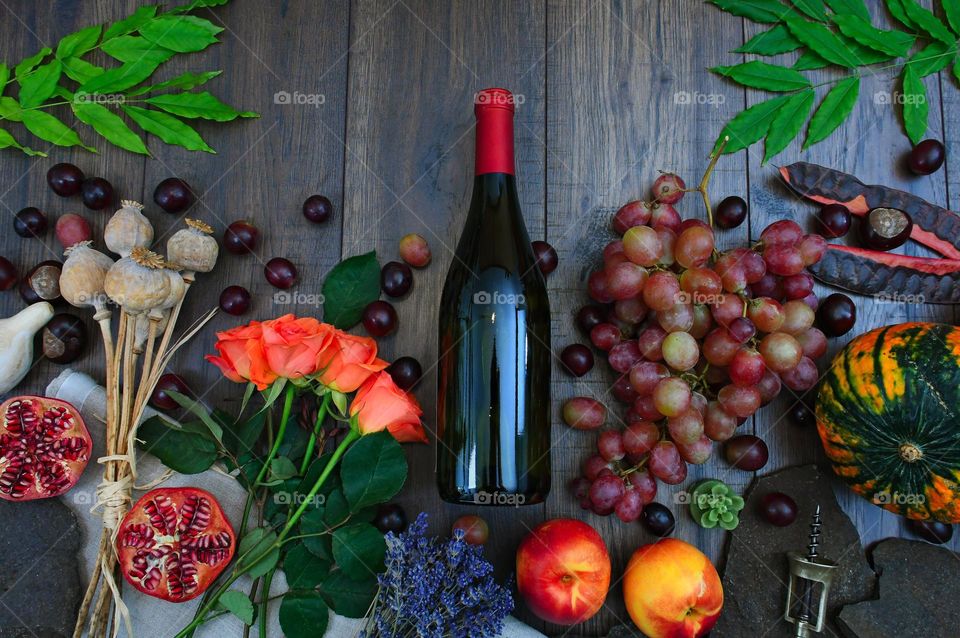 Wine bottle with fruits on wooden table