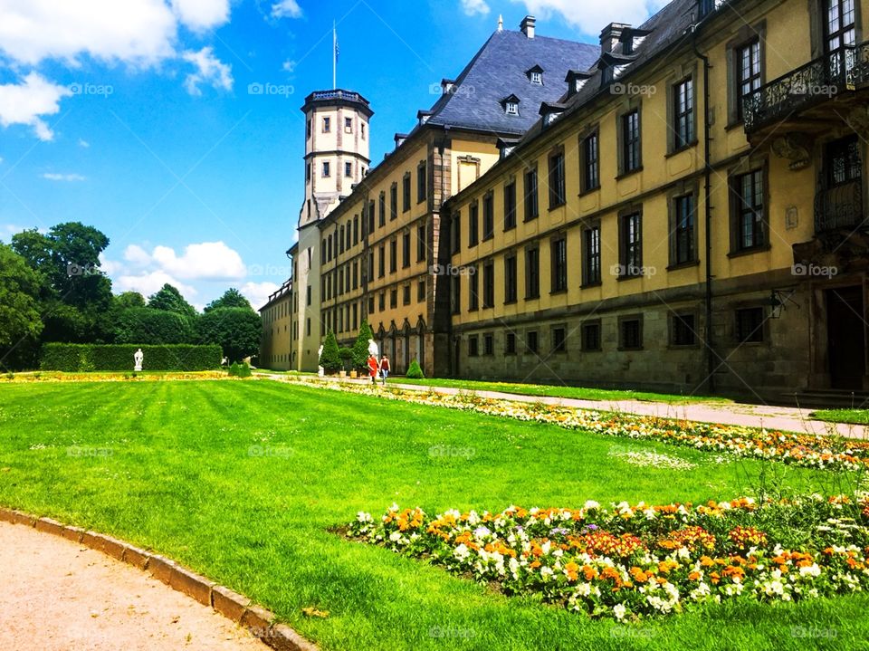 Castle in the city, with beautiful architecture, outside there are green grass and planted a variety of flowers