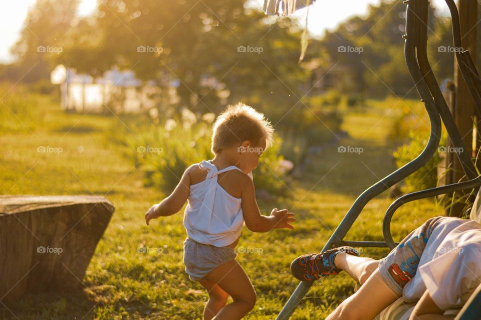 Toddler runing in the garden, and playing.