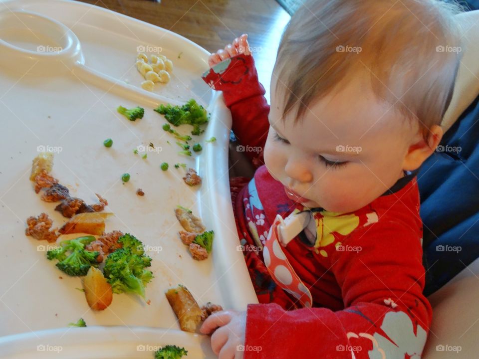 Baby Eating In A Highchair