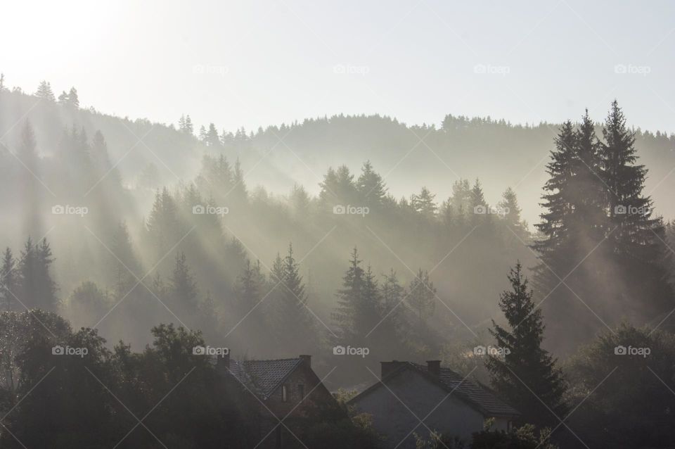 Sunbeams over the mountain and village