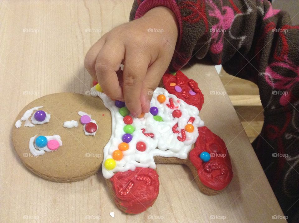 Young child is decorating gingerbread man