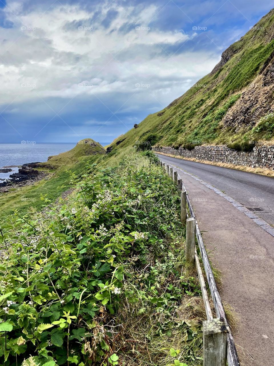 Moody skies threaten rain over a narrow road along the Atlantic in Northern Ireland.