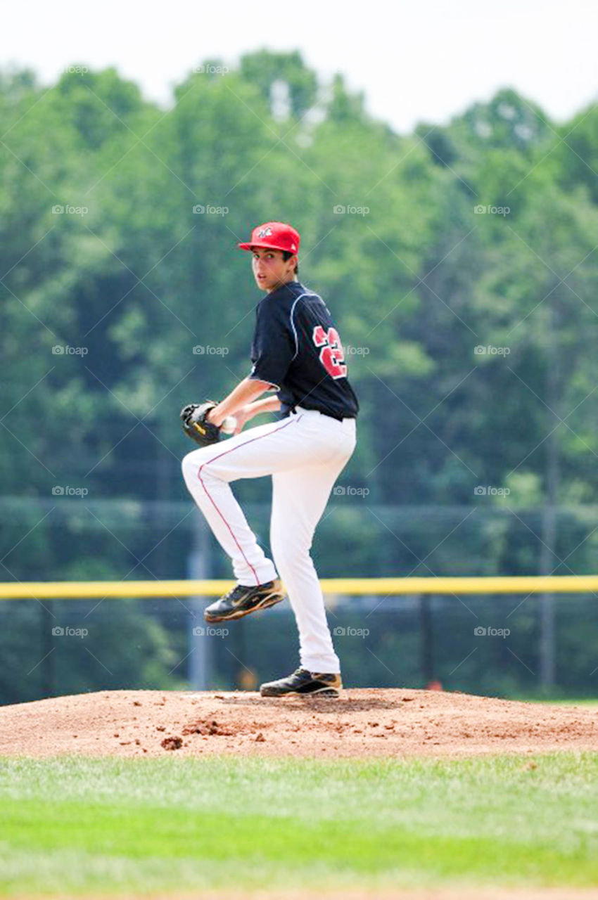 pitcher on the mound. young pitcher begins his wind up on the mound