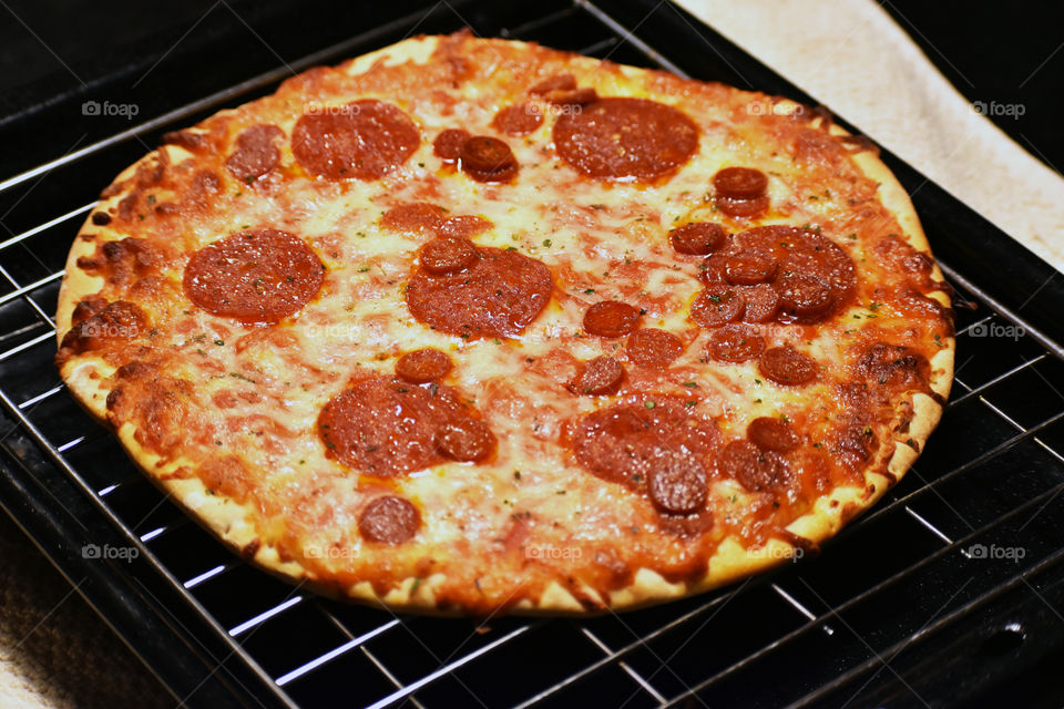 Pizza topped with mozzarella cheese and pepperoni salami, wheat flour, chopped tomatoes, water, oil, parsley, oregano and fennel.