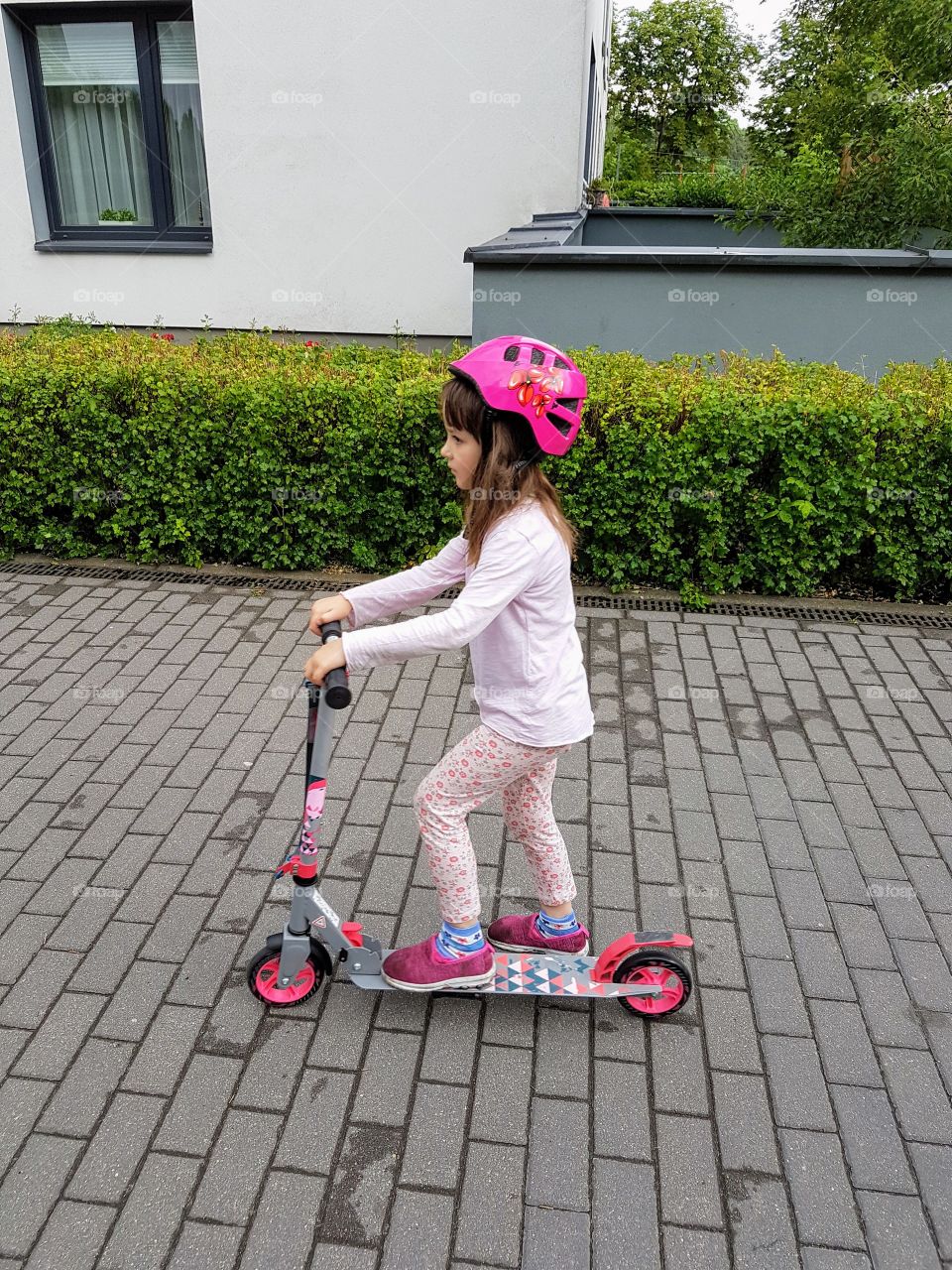 Little girl riding on scooter