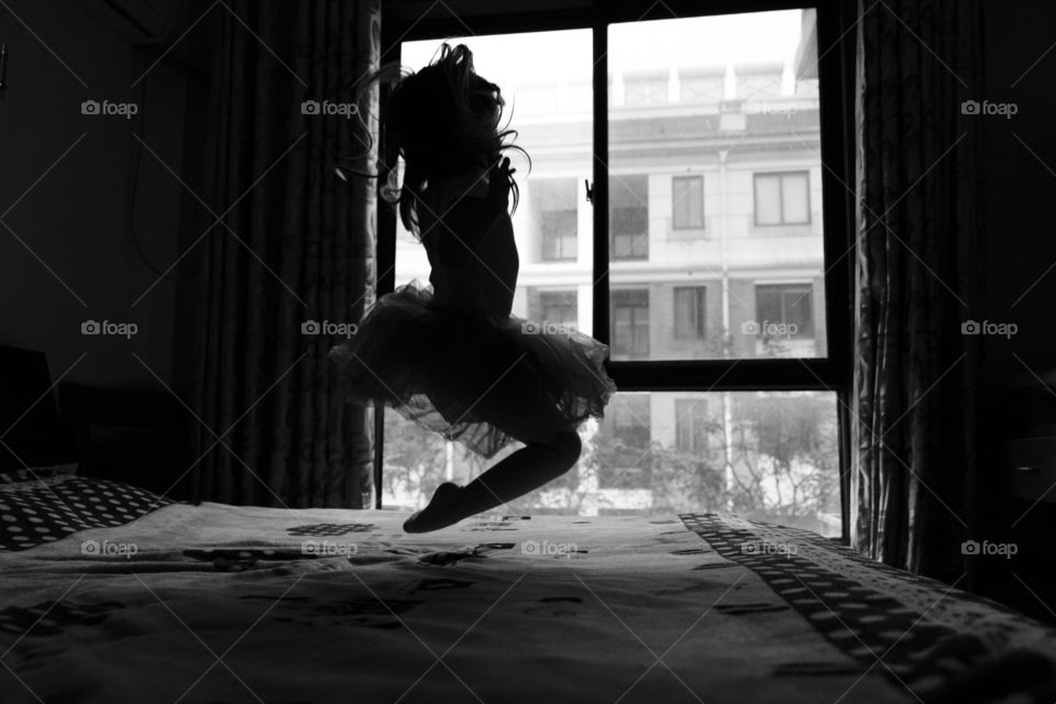 Little girl jumping on the bed 
